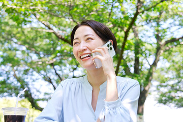 屋外でスマートフォンで電話する女性