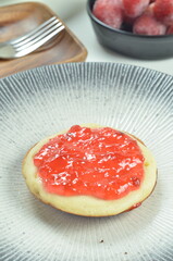 Serabi pancakes topped with strawberry jam, a traditional Indonesian snack