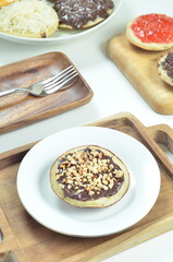 Serabi pancakes with chocolate and peanut butter toppings, a traditional Indonesian snack