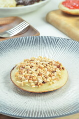 Serabi pancake with peanut topping and condensed milk, a traditional Indonesian snack