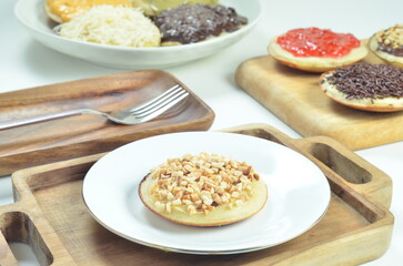 Serabi pancake with peanut topping and condensed milk, a traditional Indonesian snack