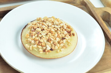 Serabi pancake with peanut topping and condensed milk, a traditional Indonesian snack