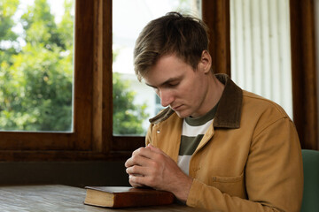 Young man holding a Bible and praying for god.