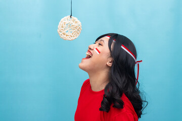 Woman smiling while participating in cracker or kerupu eating game. Great for fun competition or Indonesia Independence Day concept