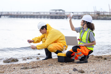 Environmental Scientists Collecting Water Samples for Analysis, Researchers Testing Water Quality and Pollution Near Industrial Area, Engineer Conducting Fieldwork for Environmental Study