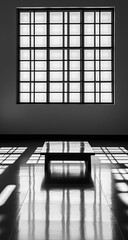 Black and white photos of the interior of the house show square windows that cast distinct shadows on the walls above, highlighting the contrast and architectural details.