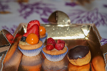 Assortment of mini desserts with fresh berries and chocolate glaze.