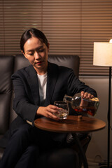 Businesswoman holding a glass of whiskey