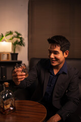 Businessman holding a glass of whiskey in a restaurant sitting on a sofa
