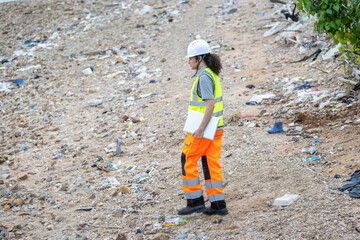 Female Engineer with Laptop Surveying Coastal Area in Safety Gear, Environmental Inspector Walking Along a Rocky Shoreline, Scientist Monitoring Beach Conditions