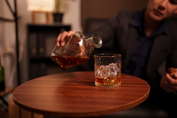 Businessman holding a glass of whiskey in a restaurant sitting on a sofa