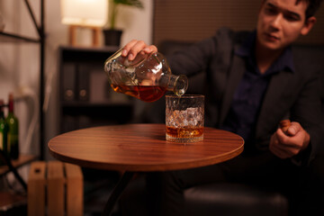 Businessman holding a glass of whiskey in a restaurant sitting on a sofa