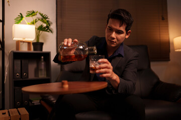 Businessman holding a glass of whiskey in a restaurant sitting on a sofa