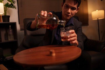 Businessman holding a glass of whiskey in a restaurant sitting on a sofa