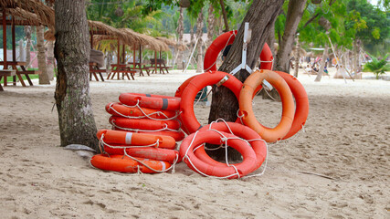Orange life jackets as swimming aids, rubber rings for swimming at rental shops. Black rubber rings...