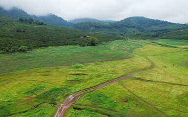 Aerial view of the reservoir, grass field and mountain views on cloudy day