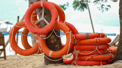 Orange life jackets as swimming aids, rubber rings for swimming at rental shops. Black rubber rings...