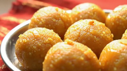 Sweet Sensation: A close-up shot captures a plate of delectable, golden-hued laddu sweets, inviting viewers with their texture and the promise of a sweet indulgence.