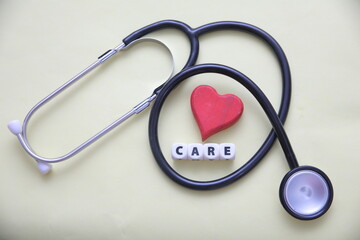 Stethoscope with Red Heart and CARE Text Blocks – Healthcare and Heart Wellness Concept