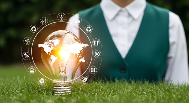Person holds lamp; World Map projection; green grass; energy icons in background; eco awareness