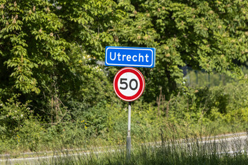 An official blue and white entrance sign for the city of Utrecht, accompanied by a red and white...