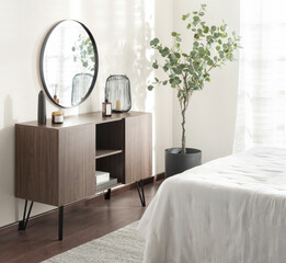 Scandinavian inspired bedroom corner in soft natural light, with walnut sideboard on black legs,...