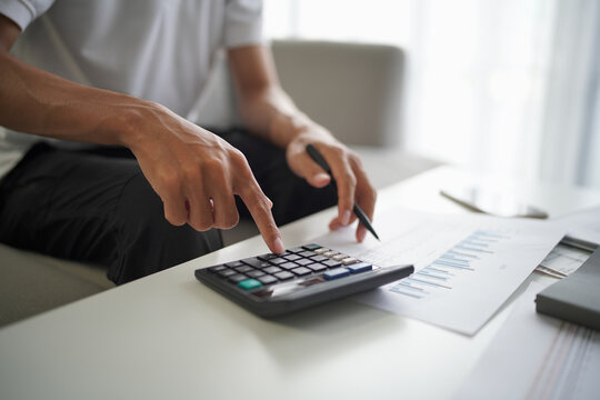 Man using calculator calculate finance and another hand holding pen