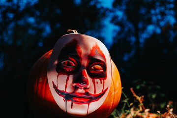  Scary pumpkin in the dark forest.Halloween wallpaper with a scary pumpkin in an ominous light in a...