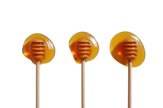 Three honey dippers, dripping with golden honey, sit vertically aligned