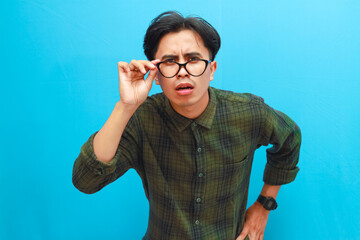 Adult Asian man lowering his glasses and showing shocked expression