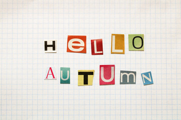 Hello autumn letters cut from newspaper on squared paper