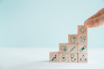 Hands holding wooden blocks with health care icons, healthcare, care plan, wellness center
