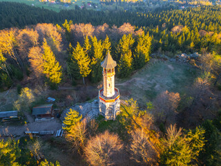 Basking in the morning light, Stepanka Lookout Tower stands tall amidst the lush greenery of the Jizera Mountains. The tranquil landscape of Korenov offers a serene escape into nature.