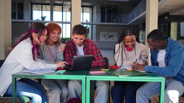 A lively group of energetic students engaged in teamwork, focused on their project while using a laptop in a collaborative atmosphere, showcasing friendship and academic dedication among peers.