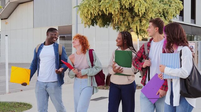 A lively group of enthusiastic students joyfully walking together on campus while discussing their educational experiences and sharing laughter, showcasing friendship and camaraderie among peers.
