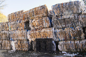 Large stacks of compressed plastic and paper bales waiting for recycling, highlighting the...