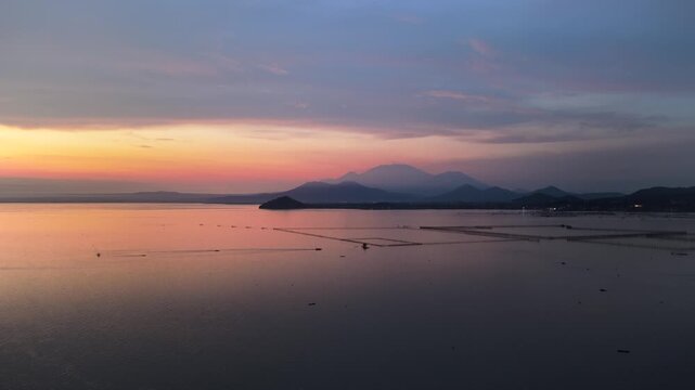 Scenic panorama aerial drone video of Mount Banahaw and Laguna de Bay during Sunrise with mist, Calamba, Laguna, Philippines