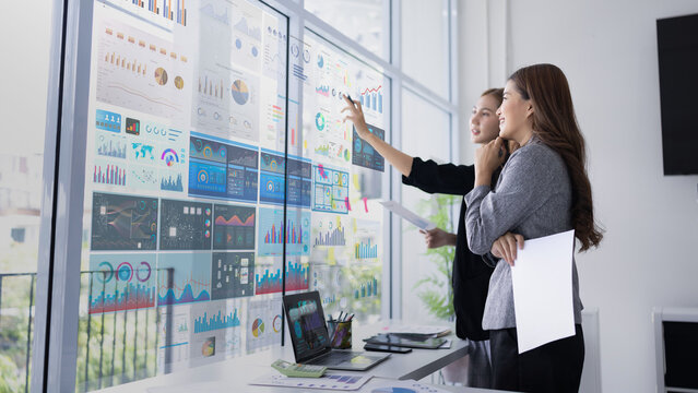 Two asian business woman working together for analysis data plan business strategies in office, Business discussing and startup concept.