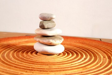Serene Stacked Stones on a Circular Wooden Base in a Minimalistic Design Setting
