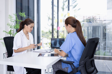 Female doctor and nurse working together, Two doctor woman working with x ray in modern clinic.
