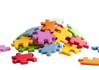 A pile of colorful jigsaw puzzle pieces, many overlapping, with some scattered around the base