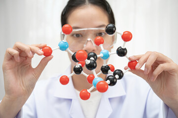 Scientist holding molecular model for chemical technology.