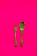 Wooden Spoon and Fork on Pink Background