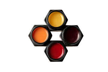 A group of five different lip balms in black glass jars arranged on top of each other to form the shape of an octagon with isolated on a transparent background in PNG format.