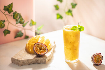 Mango passionfruit smoothie or cocktail  in drinking glass on the table. Hard light