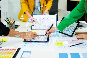 Creative team collaborating on UX/UI wireframe designs for a mobile app. Hands on planning,...