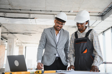 Architect and builder discussing blueprint on construction site