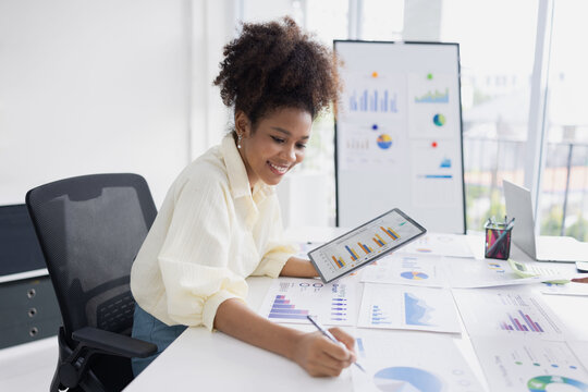 African American businesswoman with analyzing financial documents, business data charts for work online, Business finance and accounting concept. - Powered by Adobe