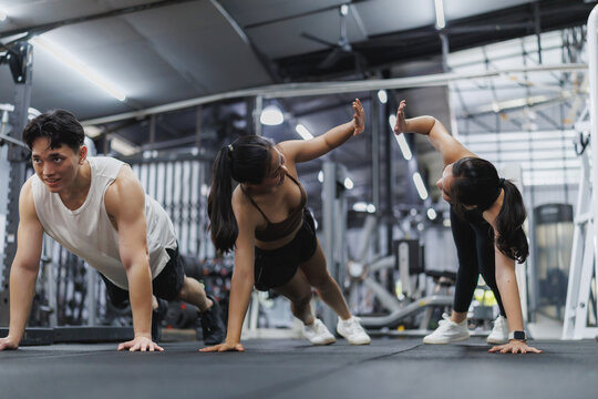 Athletes doing push ups and giving high five in gym