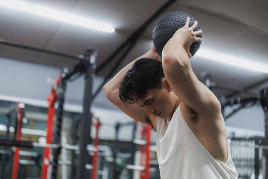 Determined athlete lifting medicine ball during cross training workout